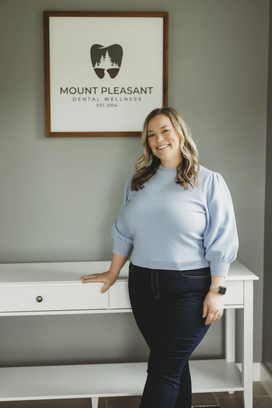 Dr. Rebecca Laliberte standing beside the Mount Pleasant Dental Wellness sign
