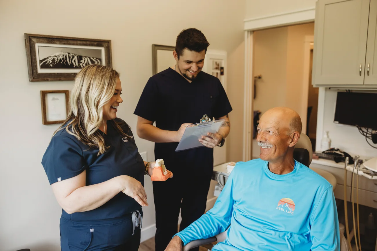 Dr. Laliberte and a team member showing a patient a dental model
